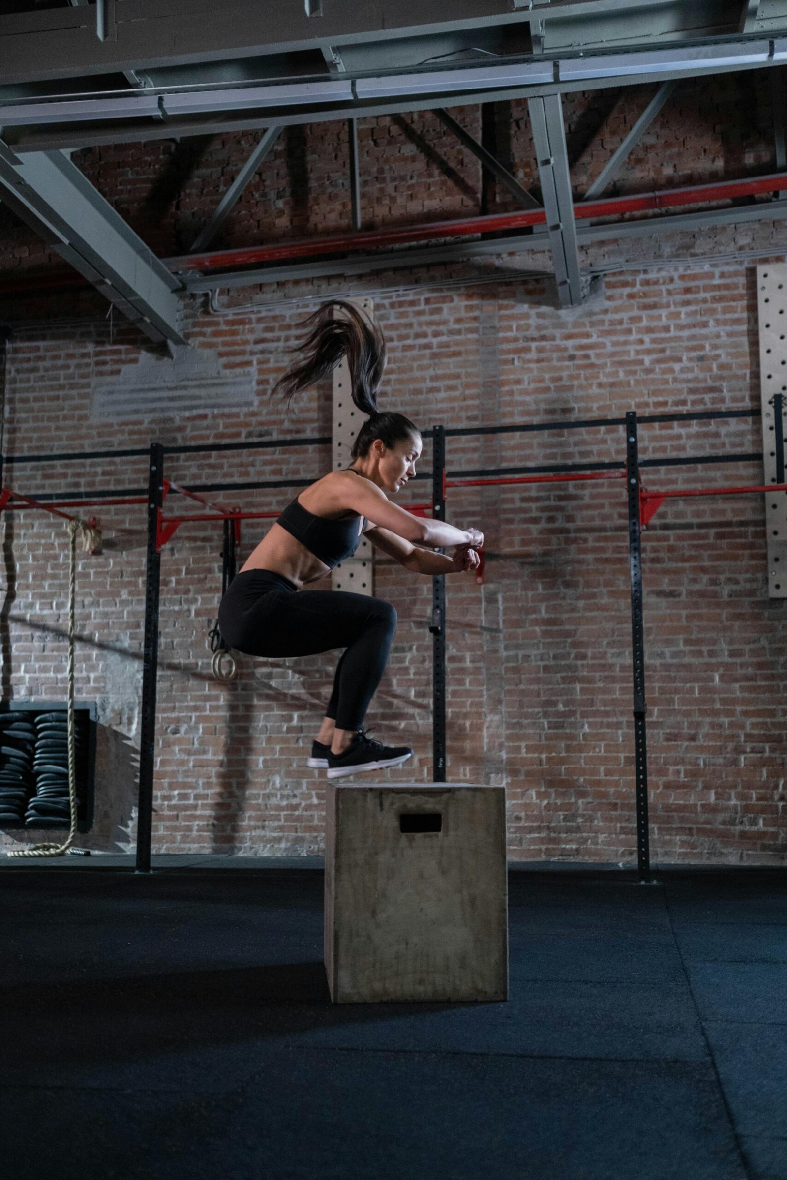 Woman doing box jumping in the gym